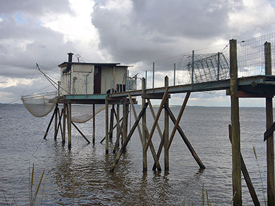 Typische Fischerbuden, von denen mit Senknetzen gefischt wird, säumen das Ufer der Gironde